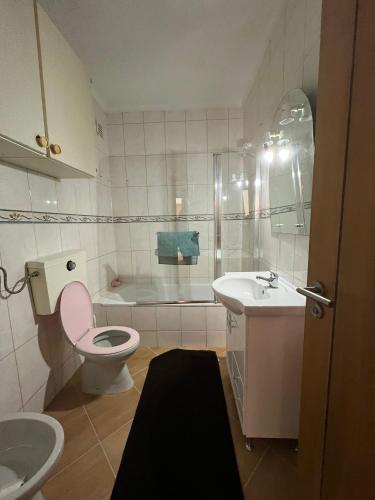 a bathroom with a pink toilet and a sink at ApartDouro in Alijó