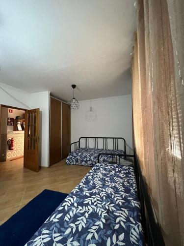 a bedroom with two beds and a curtain at ApartDouro in Alijó