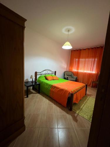 a bedroom with a bed with an orange bedspread at ApartDouro in Alijó