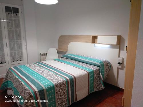 1 dormitorio con 1 cama con manta verde y blanca en CASA PUERTA DEL BOROSA, en Coto Ríos