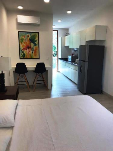 a room with a kitchen with a bed and two chairs at Estudio Cerca del mar, en Puerto Aventuras #201 in Puerto Aventuras