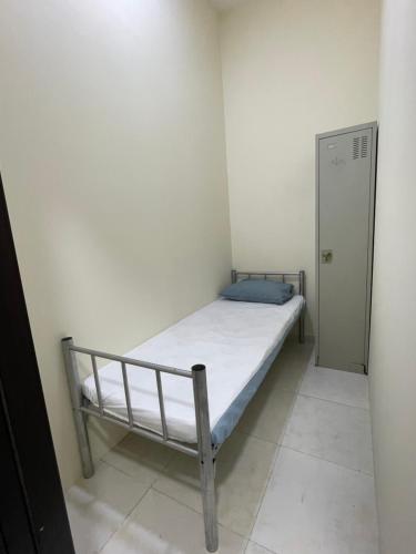 a small bedroom with a bed and a door at WAA Hostel in Dubai