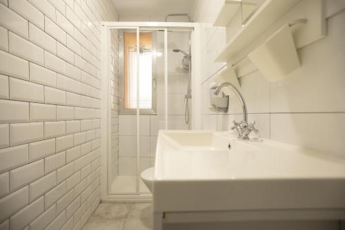 a white bathroom with a sink and a shower at Alojamientos Cantíber in Santander