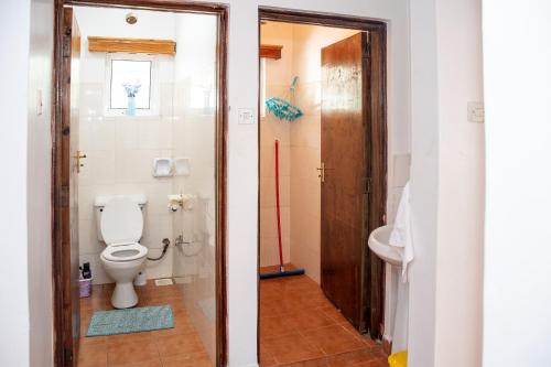 a bathroom with a toilet and a sink at The Nest Airbnb - Milimani, Kitale in Kitale