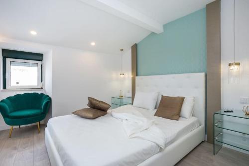 a bedroom with a white bed and a green chair at High on Lisbon in Lisbon