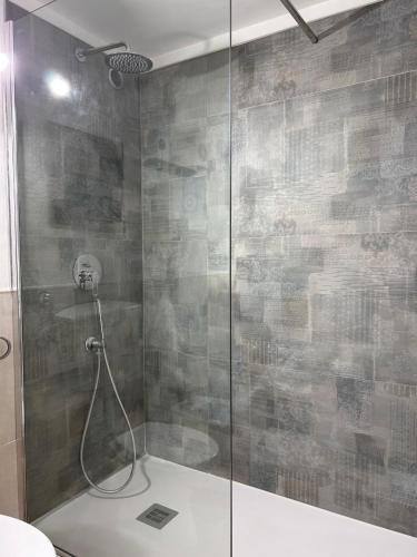 a shower with a glass door in a bathroom at Noralù House in Grottaferrata