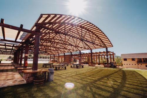 a wooden pavilion with picnic tables in a yard at Finca el Mirador in Valle de Guadalupe