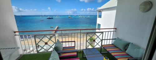 a balcony with a view of the beach and the ocean at Beau duplex vue mer avec piscine et accès plage in Marigot