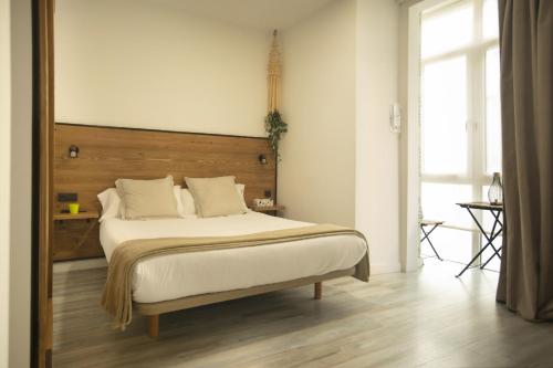 a bedroom with a large bed with a wooden headboard at Alojamientos Cantíber in Santander
