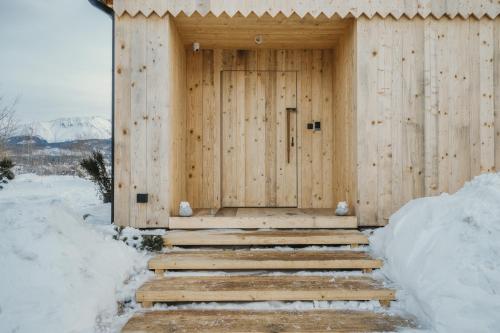 a wooden building with stairs leading to a door at SOPA Zakopane in Zakopane