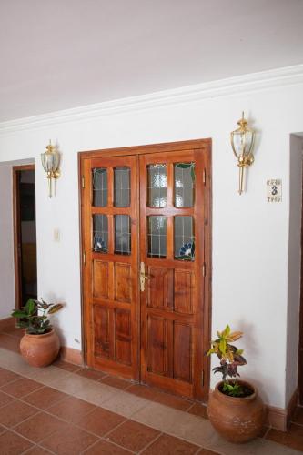 a wooden door in a room with two potted plants at Tampu in Cachí