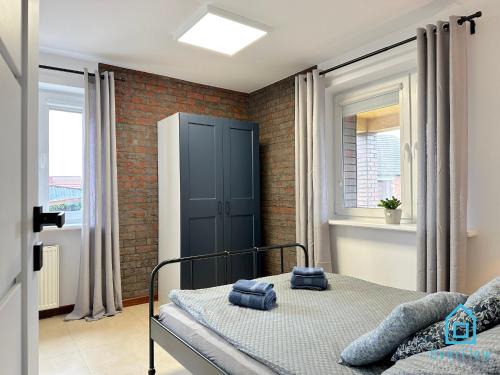 a bedroom with a bed and a brick wall at Bałtyk Apartment in Borkowo