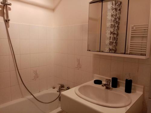 une salle de bain avec un lavabo et une baignoire dans l'établissement Rez de jardin à 100m de la mer, à Cavalaire-sur-Mer