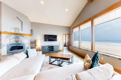 a living room with two white couches and a fireplace at Pacific City Ocean Front Escape in Pacific City