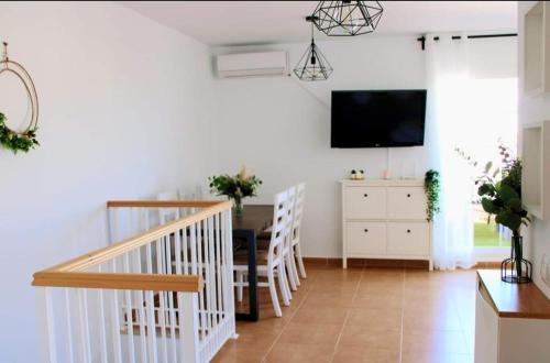 a living room with a television and a dining room at Niza Mar in Vélez-Málaga