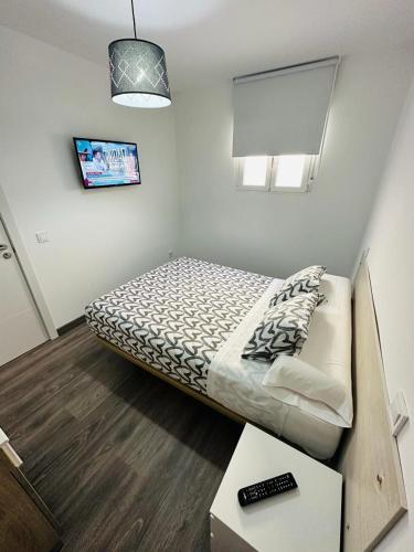 a small bedroom with a bed and a table at HOSPEDAJE NUEVA NUMANCIA in Madrid