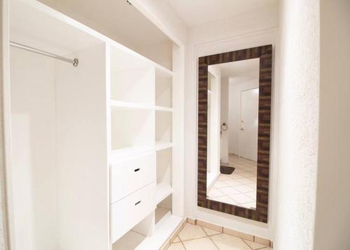 a dressing room with white cabinets and a mirror at Romantic Suite w/Beach in Heart of Acapulco in Acapulco