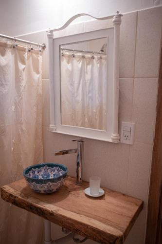 a bathroom sink with a mirror and a bowl on a table at Tampu in Cachí