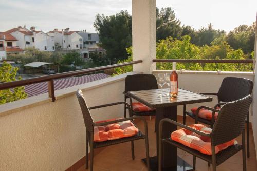 a balcony with a table and chairs and a bottle of wine at Bed and Breakfast Ritoša in Poreč