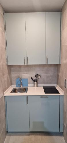a kitchen with white cabinets and a sink at Top Triana Sevilla in Seville