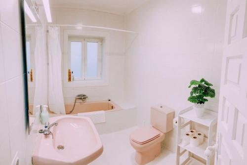 Baño blanco con aseo y lavamanos en Apartamento en Chalet La Rana Real, en La Granja de San Ildefonso