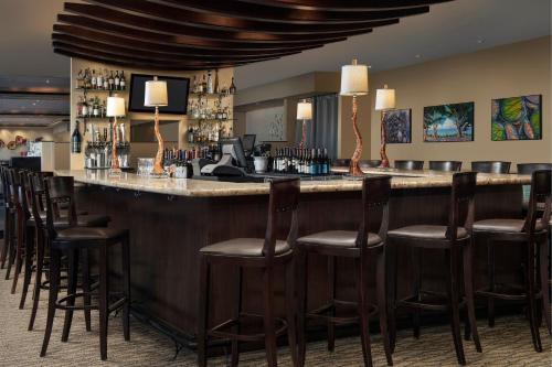 a bar in a hotel room with a bunch of stools at The Westin Sacramento Riverfront Hotel & Spa in Sacramento