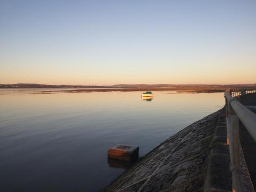 un barco en el agua junto a un muelle en Y Cuddfan Gower en Swansea