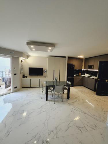 un salon avec une table et une cuisine dans l'établissement Exclusive Panoramic Sea View in Victoria Beach, à Menton