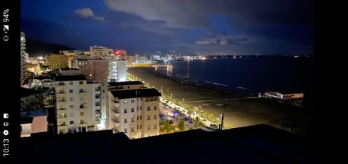 a view of a city at night with a beach at apartment by the sea in Shëngjin