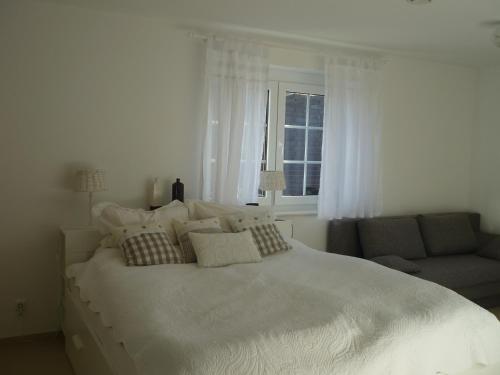 een slaapkamer met een groot wit bed en een bank bij Heidelandhaus Zühlke mit gemütlicher Südterrasse in Soltau