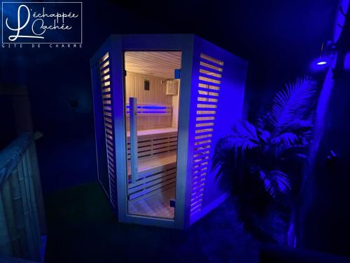 an open refrigerator with purple lights in a room at L’ Échappée Cachée - Gîte de Charme in Saint-Étienne-de-Fontbellon