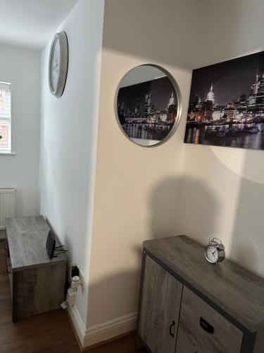 Zimmer mit einer Uhr und einem Spiegel an der Wand in der Unterkunft Beautiful- Dream Ground Floor one bedroom apartment in London
