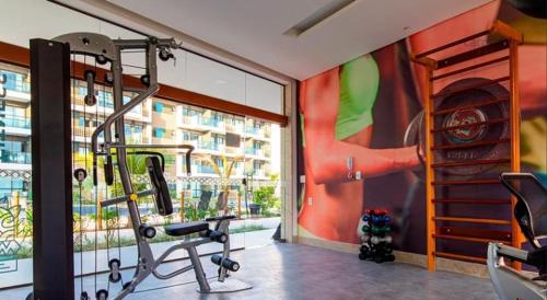 a fitness room with a gym with a large window at Beautiful studio Muro Alto mana beach in Ipojuca