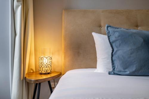 een bed met een blauw kussen en een lamp op een tafel bij Oporto Wine Cellars Flat With Terrace in Vila Nova de Gaia