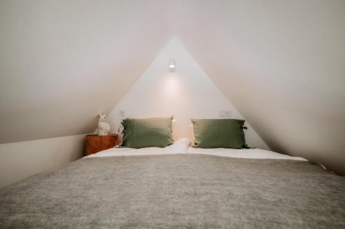 a bed with green pillows in a room at SOPA Zakopane in Zakopane