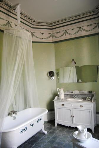 une salle de bain avec une baignoire, un lavabo et un miroir dans l'établissement Château d'Urtubie, à Urrugne