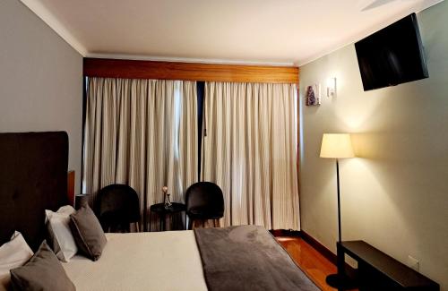 a hotel room with a bed and a window at São Cristóvão Nature Country Hotel in Venda Nova