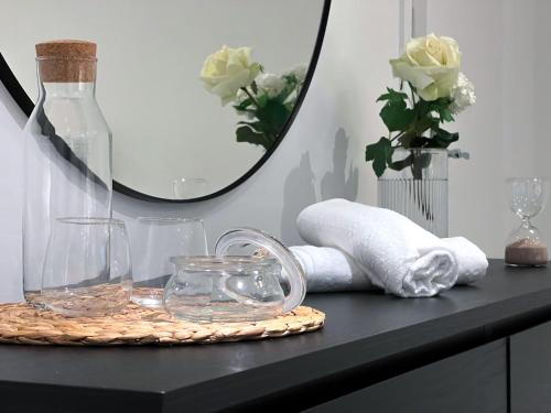 a black table with a mirror and towels and a vase at Stylish 3 bed flat with Garden in London