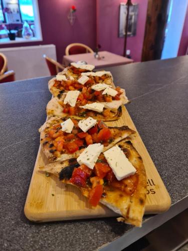 four slices of pizza on a cutting board on a counter at Pizzeria Pension Damiano in Muldenhammer