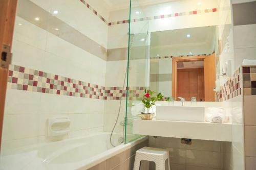 ein Bad mit einer Badewanne, einem Waschbecken und einer Dusche in der Unterkunft Hotel Marabout - Families and Couples Only in Sousse