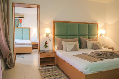 a bedroom with a large bed and a mirror at Hotel Marabout - Families and Couples Only in Sousse