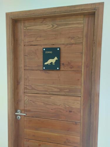 a wooden door with a dog sign on it at Hotel HORSTMEYER in Cochrane