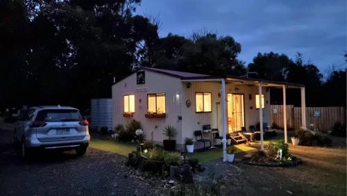 a car parked in front of a house at night at Winganah Cottage in Murdunna