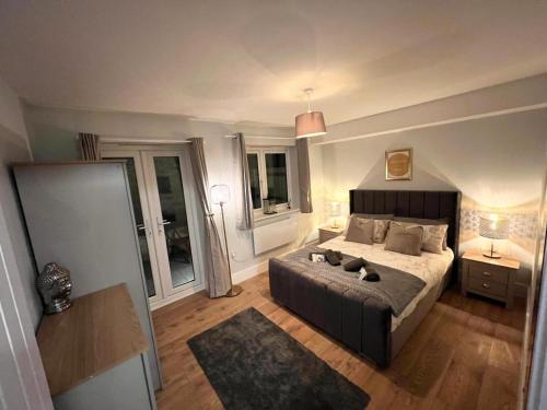 - une chambre avec un grand lit et 2 fenêtres dans l'établissement Homes from home by Tulloch Properties, à Maidstone
