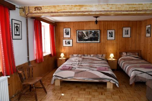 een slaapkamer met 2 bedden en rode gordijnen bij Pri Matičku in Bohinj