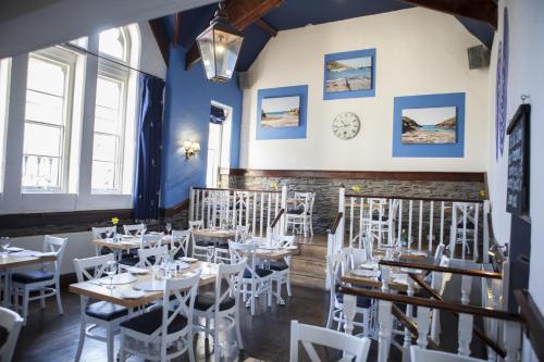 a dining room with tables and white chairs at The Old School Hotel in Port Isaac