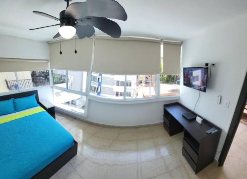 a bedroom with a blue bed and a large window at R10 Lindo Apto de 5 recámaras, zona turística. in Panama City