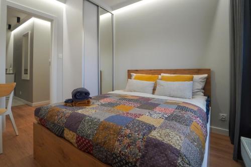 sypialnia z łóżkiem z kolorową kołdrą w obiekcie Apartament Manhattan w mieście Płock