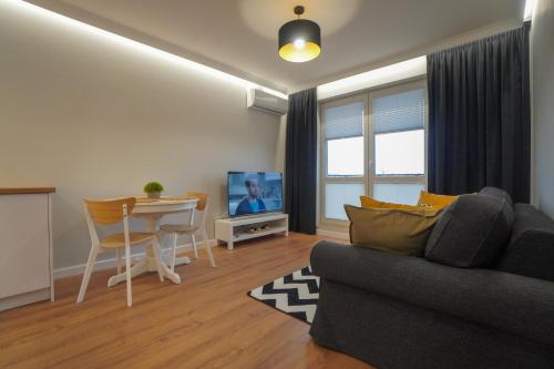 a living room with a couch and a table at Apartament Manhattan in Płock