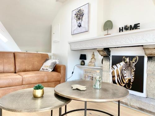 un salon avec un canapé et une table dans l'établissement LE NID DES QUAIS - Vue Panoramique au cœur de la ville - Wifi - Entrée autonome, à Quimper